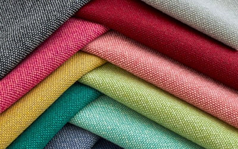 Các mẫu vải xám, đỏ, hồng, vàng và xanh xếp cạnh nhau, minh họa nhóm màu vải cotton