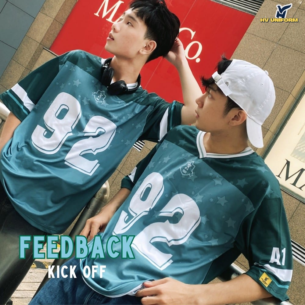Áo lớp xanh Kick Off năng động AL404, bố cục hai nữ đội mũ