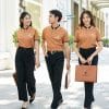 Đồng phục công ty màu vàng đồng - TT108, ba người đi dưới mái vòm