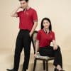 Đồng phục công ty đỏ đô - TT505, nam đứng cạnh nữ ngồi ghế