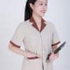 Bộ buồng phòng khách sạn màu be phối vest, nữ đứng nghiêng cho tay vào túi