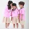 Đồng phục mầm non màu hồng đào phối quần váy sữa - MN104, ba bé nghiêng đầu nhìn nhau