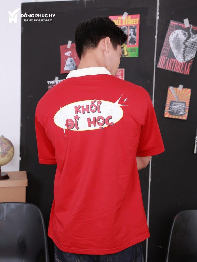 Lưng áo polo đỏ có mảng hình trắng và chữ Khối đi học